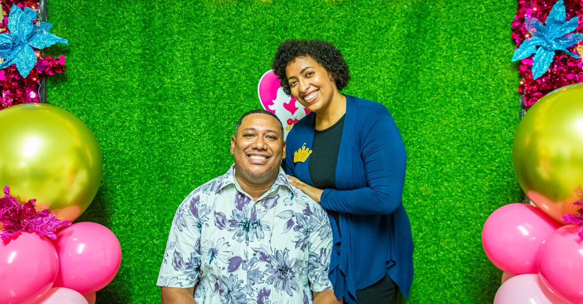 lovely couple celebrating with colorful balloons and vibrant smiles against a green backdrop