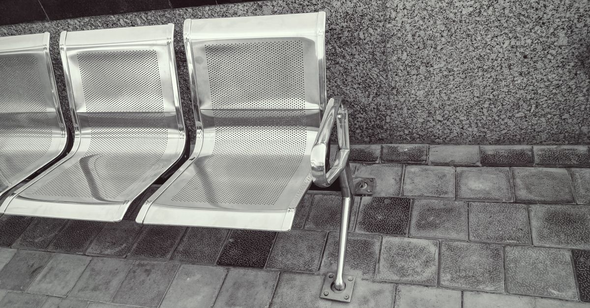 modern stainless steel benches with granite wall and tile flooring in an outdoor setting